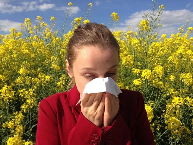 woman with allergies in a field of flowers