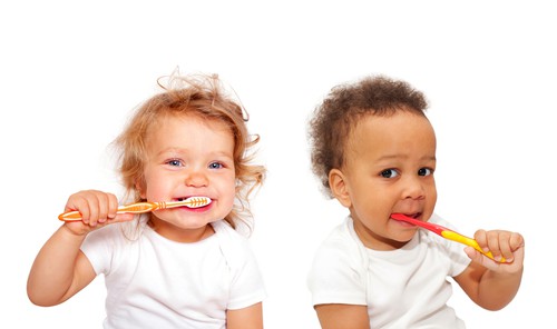 2 toddlers brushing their teeth