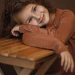 smiling young girl leaning on table
